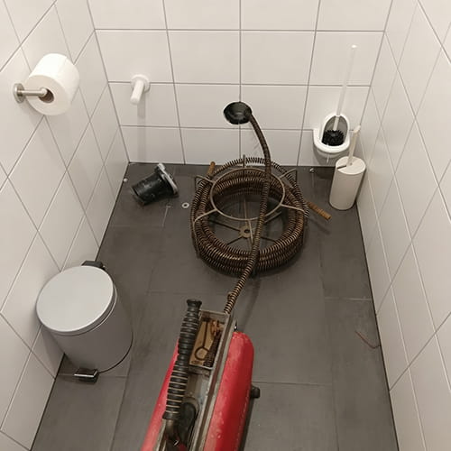 Rohrreinigung mit elektrischer Spirale im WC.